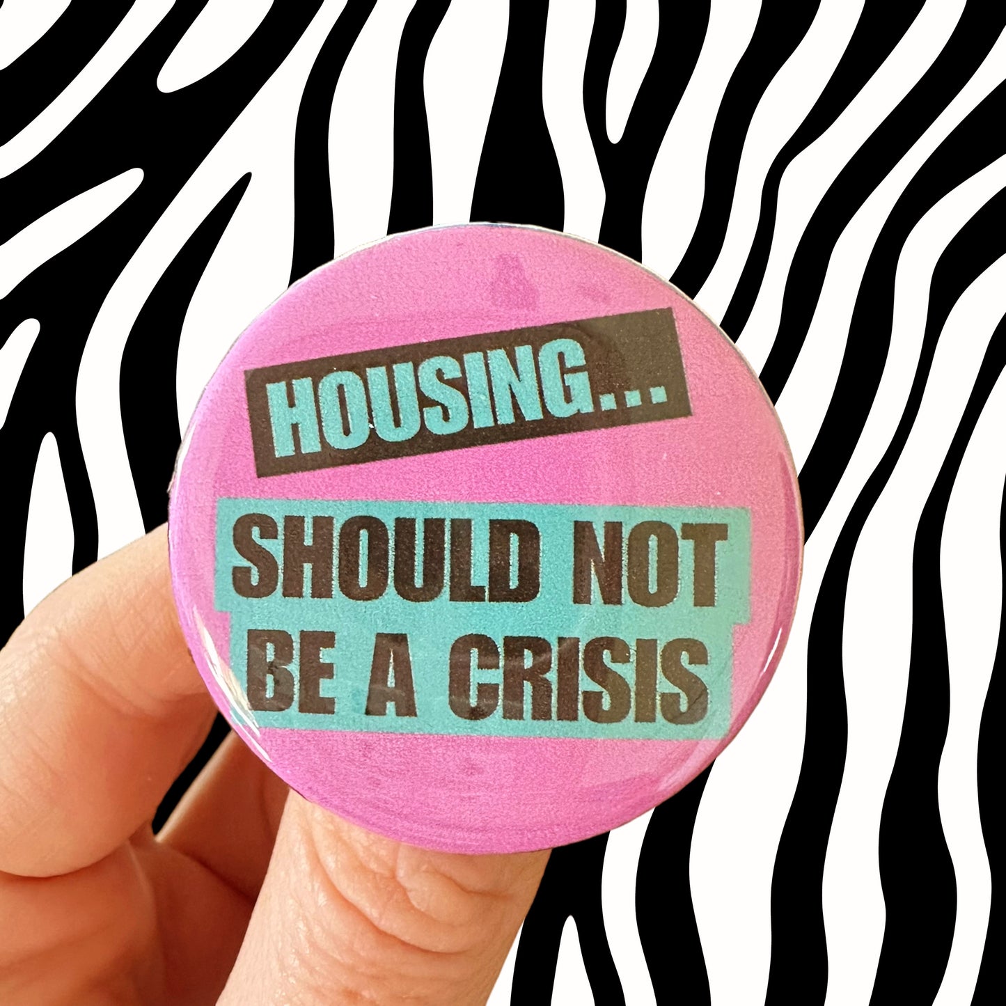 Light Purple and Teal Button Badge “Housing…should not be a crisis”